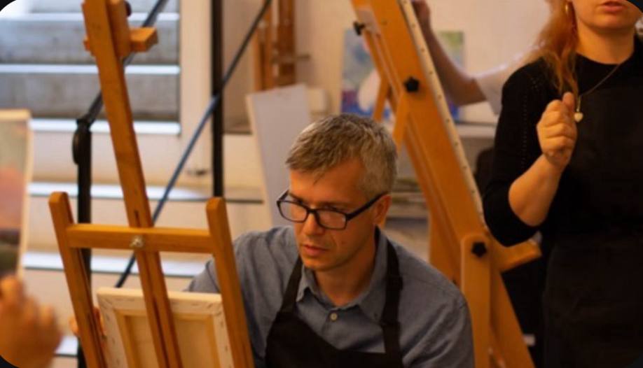 A student painting at an easel during the course